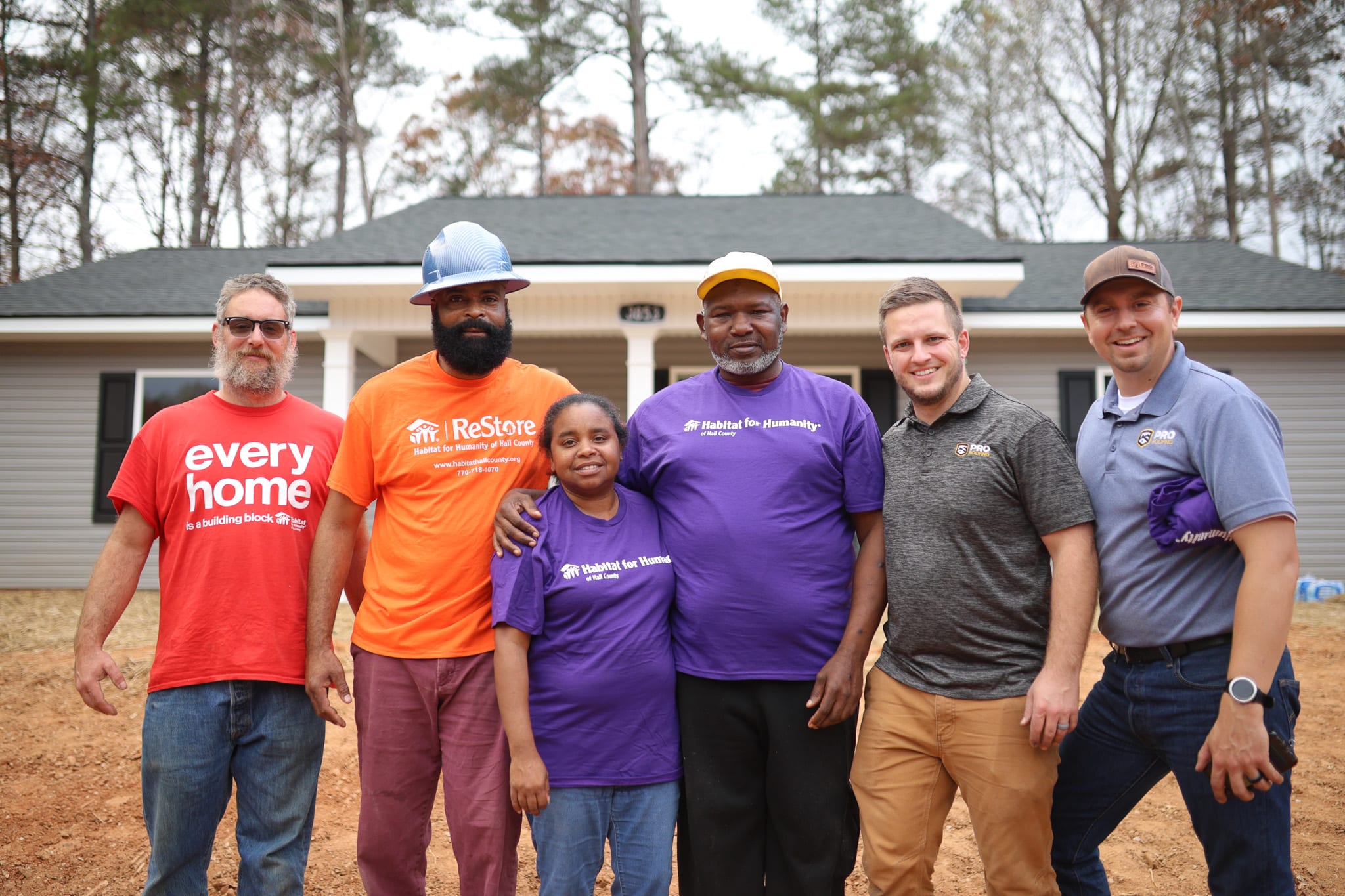 6 people standing in front of a roofing project done by ProRoofing for Habitat For Humanity