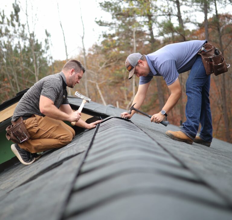 two ProRoofing team members on a roof installing a roof replacement